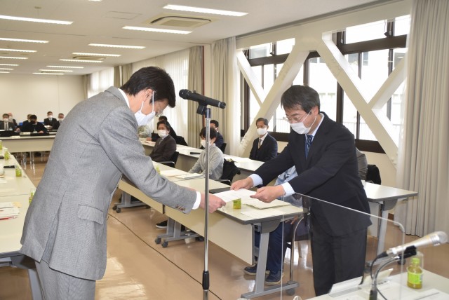 斉藤市長（手前左）から諮問書を受け取る小泉会長＝熱海市役所