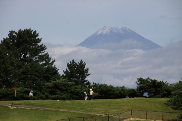 プレーを楽しむゴルファーの向こうにそびえる初冠雪した富士山＝伊豆市の伊豆国際カントリークラブ