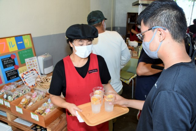 ドライフルーツ入りの炭酸飲料水をサービスする「ミセスこらってぃ」メンバー＝東伊豆町稲取のダイロクキッチン