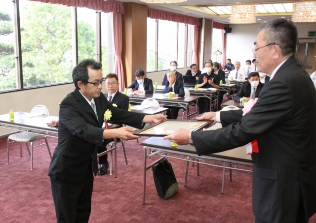 石渡会長（右）から表彰状を受け取る表彰者＝伊豆の国市のホテルサンバレー富士見