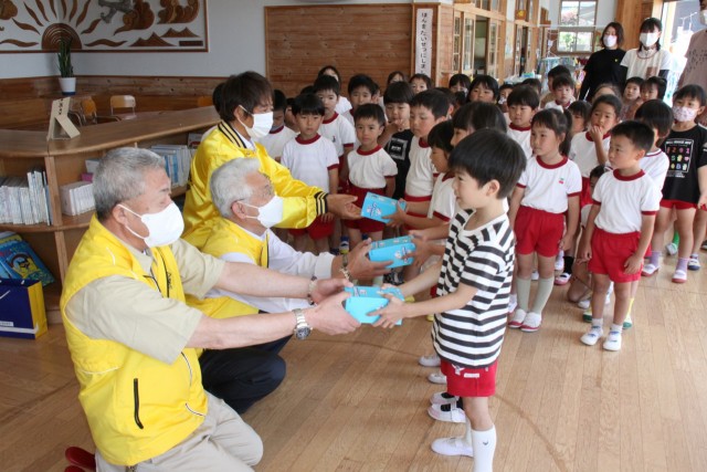 園児の代表に歯ブラシを手渡す韮山ライオンズクラブメンバー＝伊豆の国市の富士美幼稚園