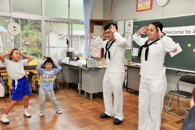 日米交流会で米国水兵と一緒にダンスを踊る児童＝下田市の朝日小（１９日）