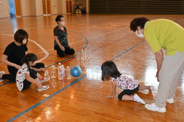 ペットボトルに向かってボールを投げる子ども＝熱海市下多賀の南熱海マリンホール