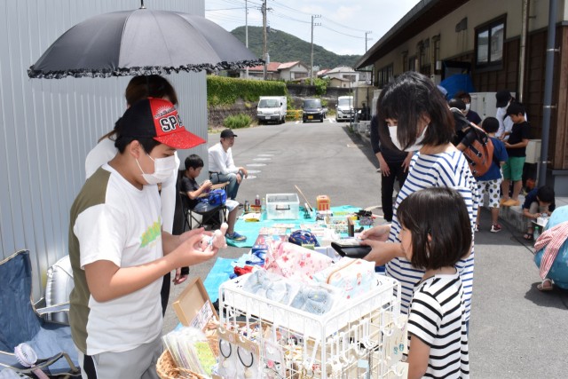 「こどもフリマ」で小物を売る子ども（左）＝西伊豆町仁科のはんばた市場