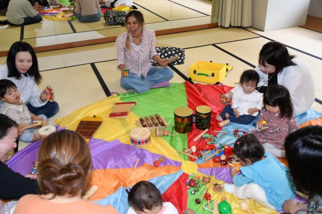 桜井さん（中央）と一緒に英語リトミックを楽しむ親子連れ＝伊東市の生涯学習センター池会館