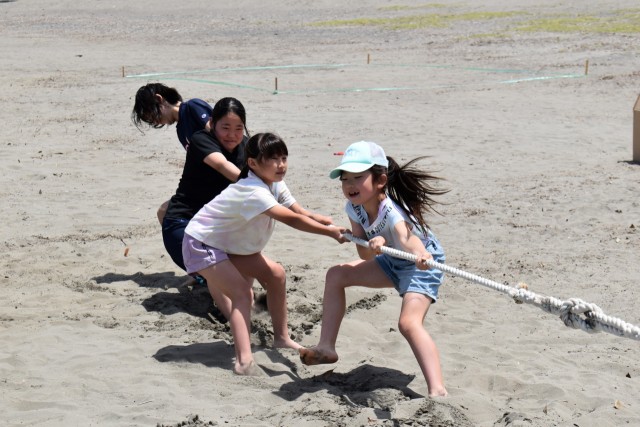松崎西区の区民大会で綱引きを楽しむ子どもたち＝松崎町の松崎海岸（２８日）