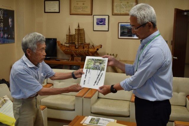 発行した冊子を寄贈する土屋さん（左）＝松崎町役場