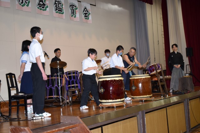 和太鼓奏者の手ほどきを受け演奏に挑戦する生徒たち＝河津町の河津中