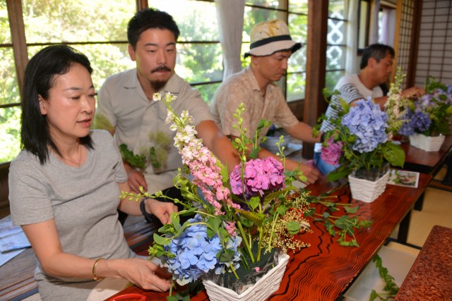 鈴木さん（左から２人目）の指導で花を生ける参加者＝下田市一丁目の雑忠