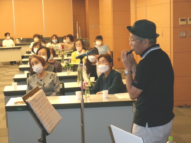 総会後、オカリナ演奏を披露する松本さん（手前）と聴き入る会員たち＝函南町役場