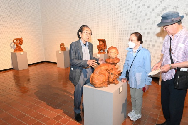 来館者に作品を説明する前島さん（左）＝伊東市十足の池田２０世紀美術館