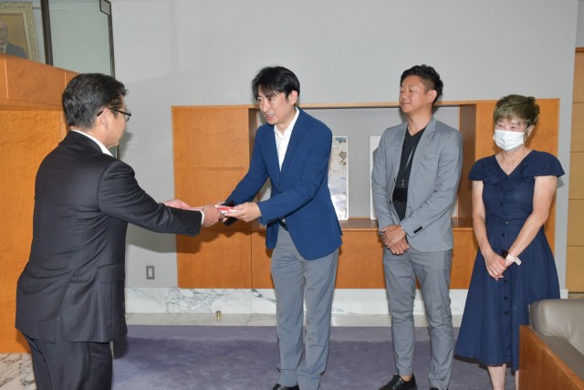 小野市長（左）に寄付の目録を手渡す川村代表＝伊東市役所