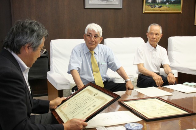 山下市長（左）にダブル受賞を報告する堀江理事長（中）と関森副理事長＝伊豆の国市役所