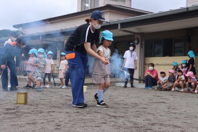 女性消防隊の指導で花火の扱い方を実習する園児＝東伊豆町のひがしいず幼稚園