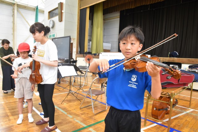 バイオリンなどの楽器演奏を体験する児童＝下田市の下田小
