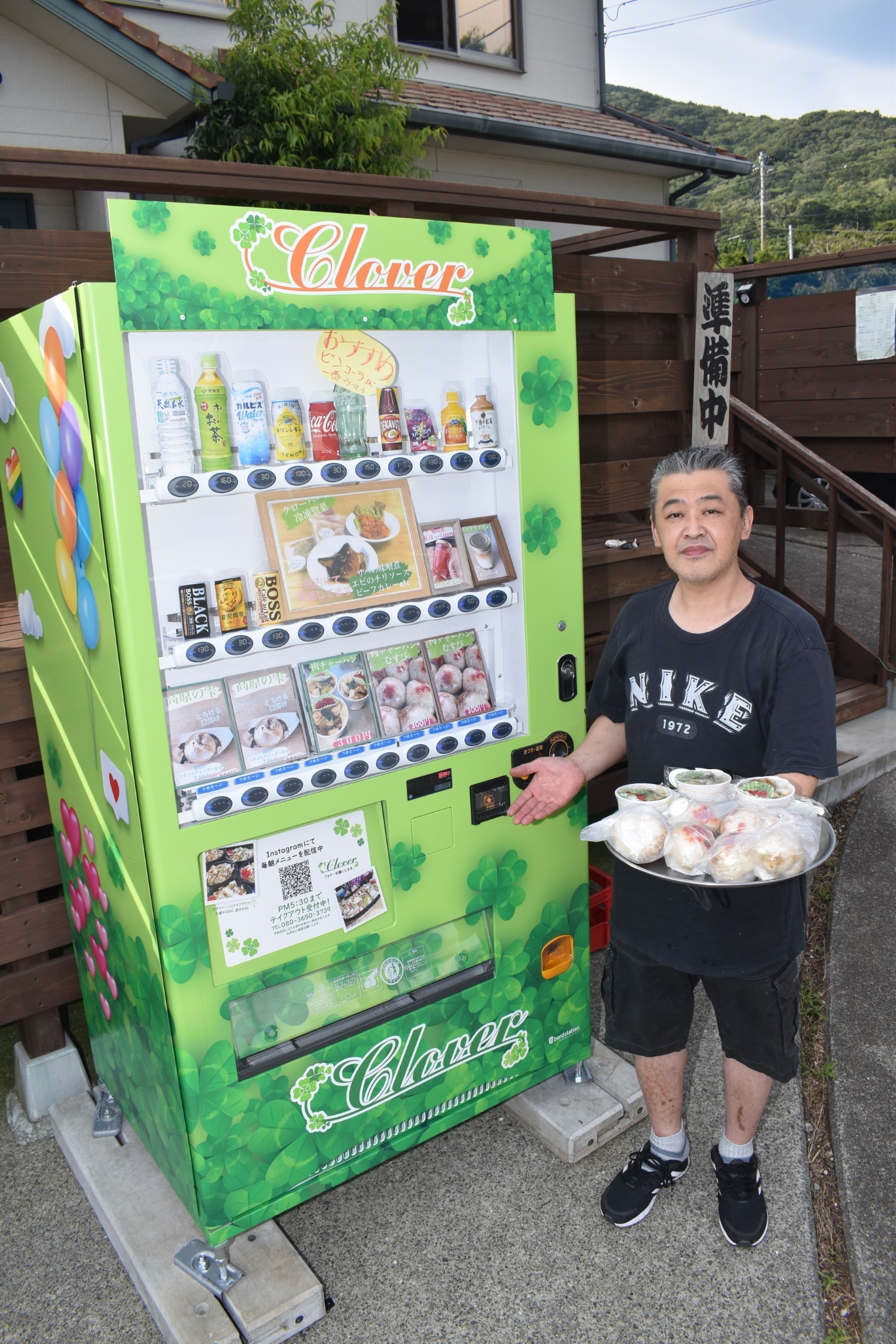 店先に設置した肉チャーハンの自販機をアピールする古屋さん＝東伊豆町稲取