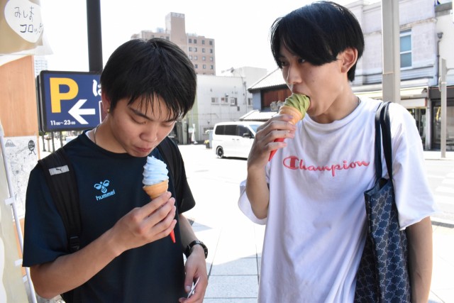 ソフトクリームを食べて涼をとる男性＝三島市内