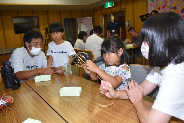 開館３１周年の記念イベントで保護者と一緒に「お花の万華鏡」作りを楽しむ子ども＝東伊豆町立図書館（２９日）