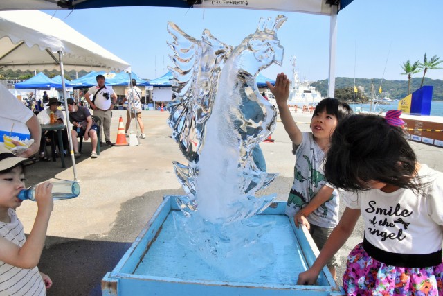 「マリンフェスタ下田２０２３」で制作された氷の彫刻を触って喜ぶ子どもたち＝下田市の道の駅・開国下田みなと周辺（２２日）