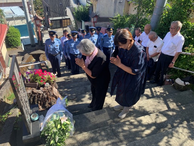 顕彰碑に献花と焼香し、手を合わせる子孫と警察官ら＝熱海市伊豆山