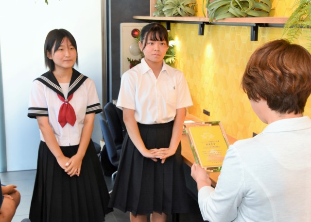 選考委員長の池田さんから表彰の盾を受ける（左から）永田さん、高橋さん＝伊豆市柏久保