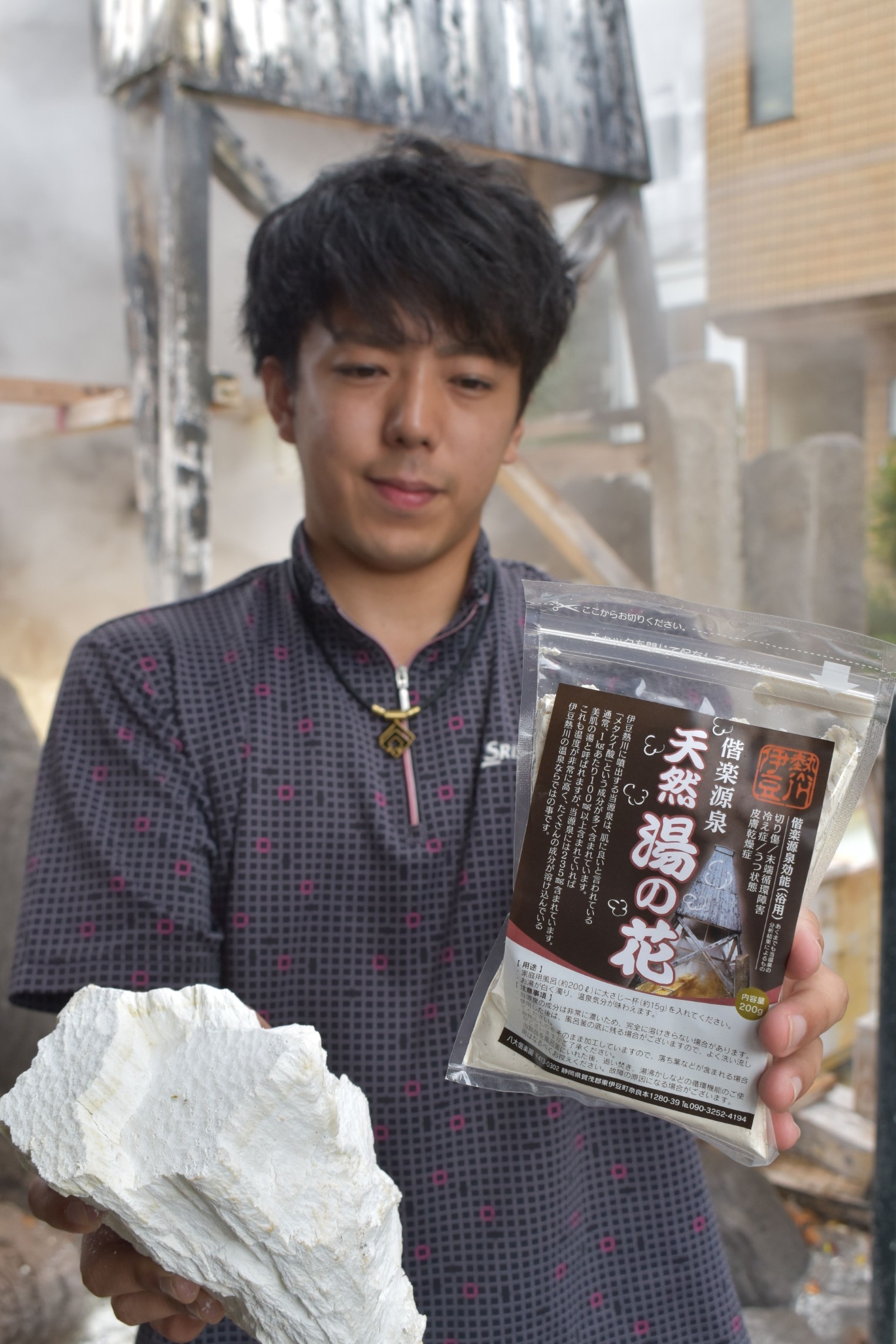 偕楽源泉で採取した湯の花と、商品化した入浴剤を手にする斉藤さん＝東伊豆町奈良本