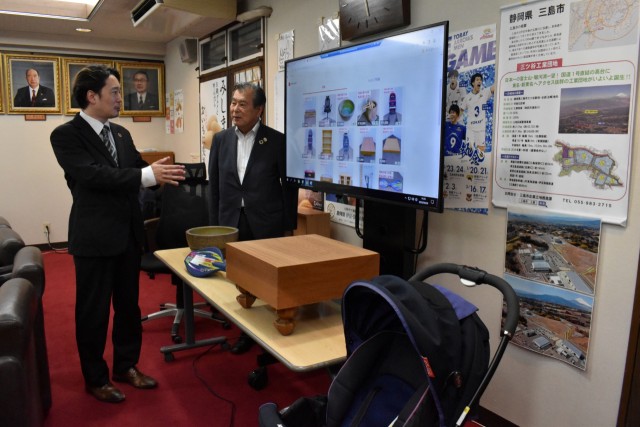 メルカリに出品された品を見ながら意見を交わす豊岡市長と高橋さん（左）＝三島市役所
