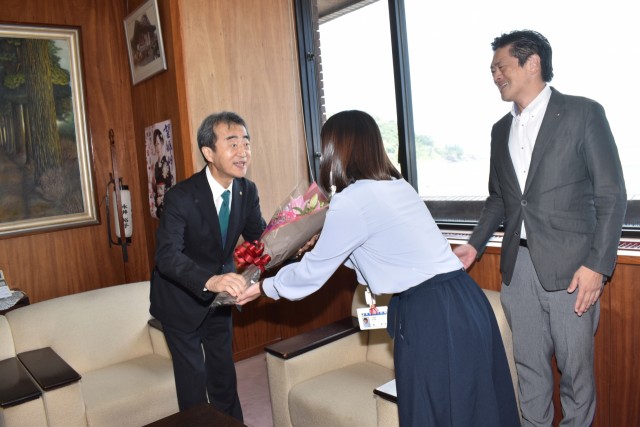 町職員から花束を受け取る今井・岡谷市長（左）＝東伊豆町役場