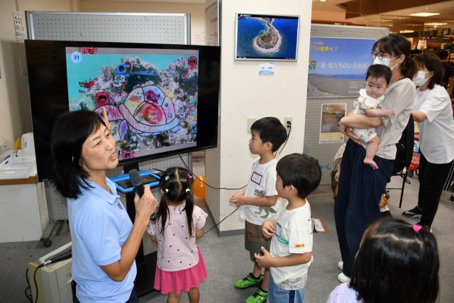 テレビモニターで動く絵を眺める子どもたち＝伊東市玖須美元和田の伊東ショッピングプラザ・デュオ