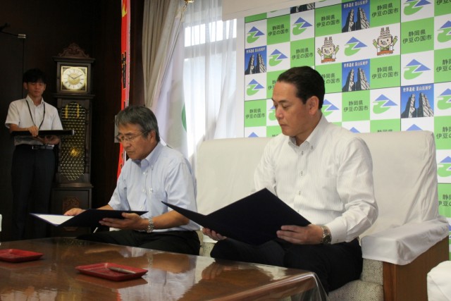 署名した協定書を確認する松尾支社長（右）と山下市長＝伊豆の国市役所