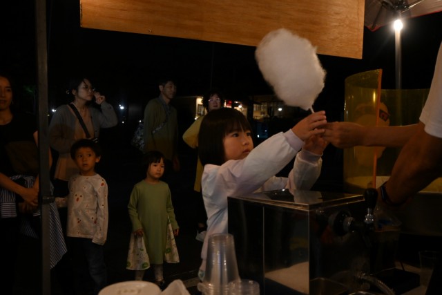 中秋の名月にちなんだ「伊豆高原オータムフェスティバル大室山観月祭」で、綿菓子を受け取る子ども＝伊東市の大室山リフト第１駐車場（２９日）