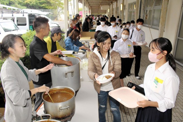 地元飲食店が協力した温かい食事を受け取る生徒（右）＝熱海市の多賀中（画像の一部を加工してあります）
