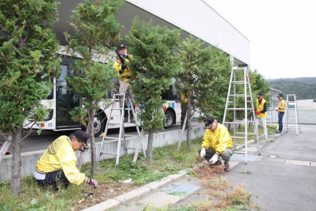 樹木の剪定や草取りを進めるメンバー＝伊豆の国市の県東部特別支援学校