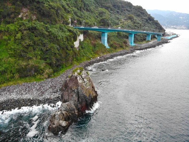 国道１３５号真下の海岸にそびえ、トンネルの名に取られた立岩＝熱海市網代
