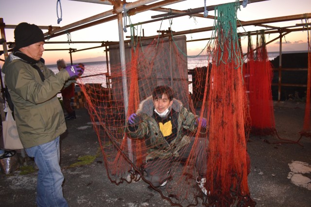 網に絡みついた海藻などを取り除く参加者＝河津町の谷津漁港