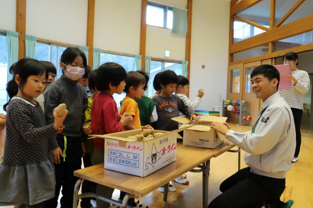 帯広市から届いたジャガイモを手に取る子どもたち＝松崎町の聖和保育園