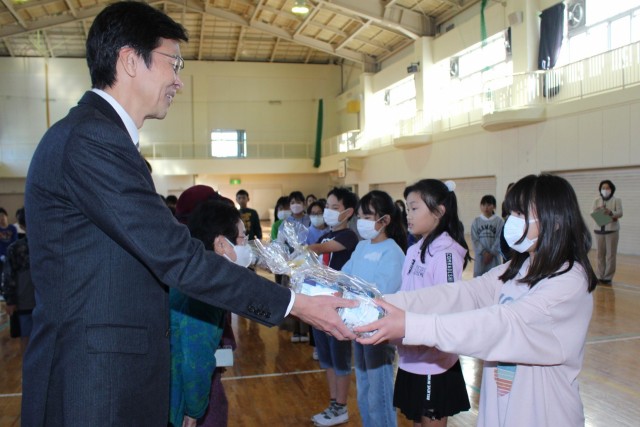 代表児童にトイレットペーパーを手渡す斉藤市長ら（左）＝熱海市の多賀小