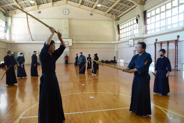 菊地会長（手前右）から剣道形を学ぶ剣士＝熱海市の桃山小体育館