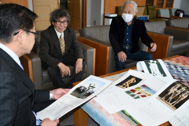 完成した新年のカレンダーを紹介する重岡さん（左）と武智さん＝伊東市役所