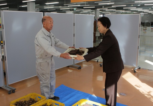 鈴木会長（右）にサツマイモとサトイモを手渡す土屋さん＝伊東市桜木町の市健康福祉センター