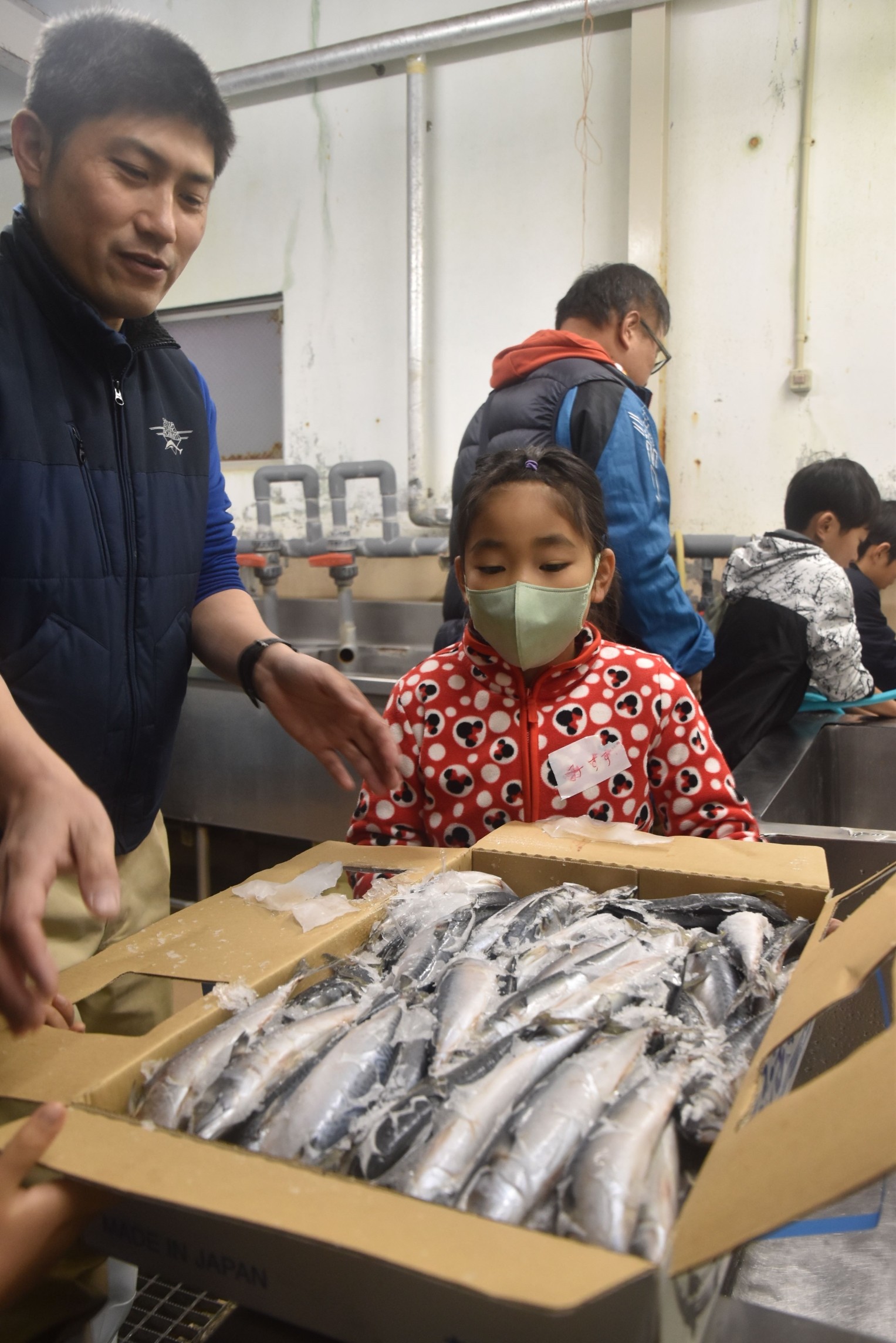 オープン前の水族館で魚を解凍して餌の準備を体験する子ども＝下田市の下田海中水族館（１０日）