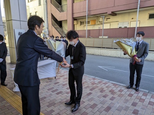職員２人に梅の枝を託す斉藤市長（左）＝熱海市役所