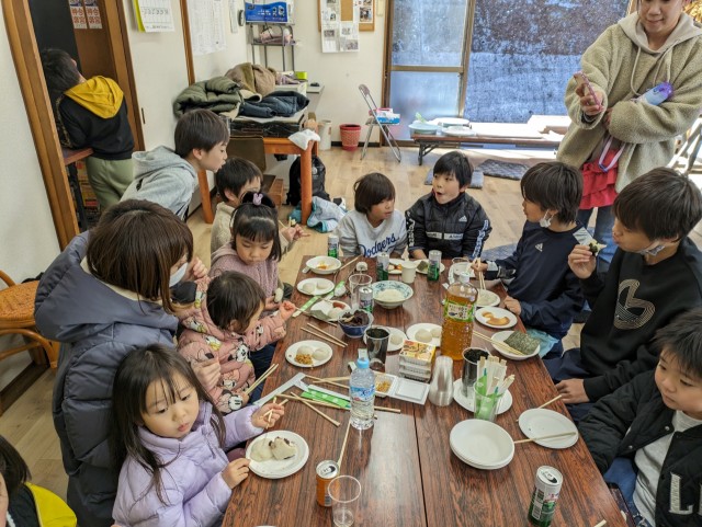 町内会のもちつき大会でつきたての餅をほお張る子どもたち＝熱海市の桜木町公民館（１７日）