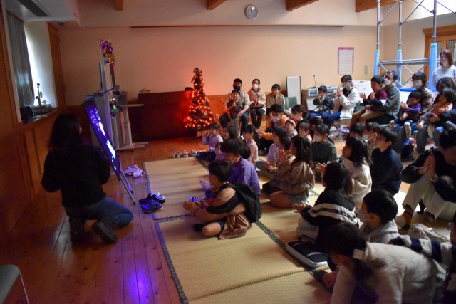 「かわづっこ子育てねっと」のクリスマスお楽しみ会で、ブラックパネルシアターを楽しむ子どもたち＝河津町の町立文化の家（１７日）