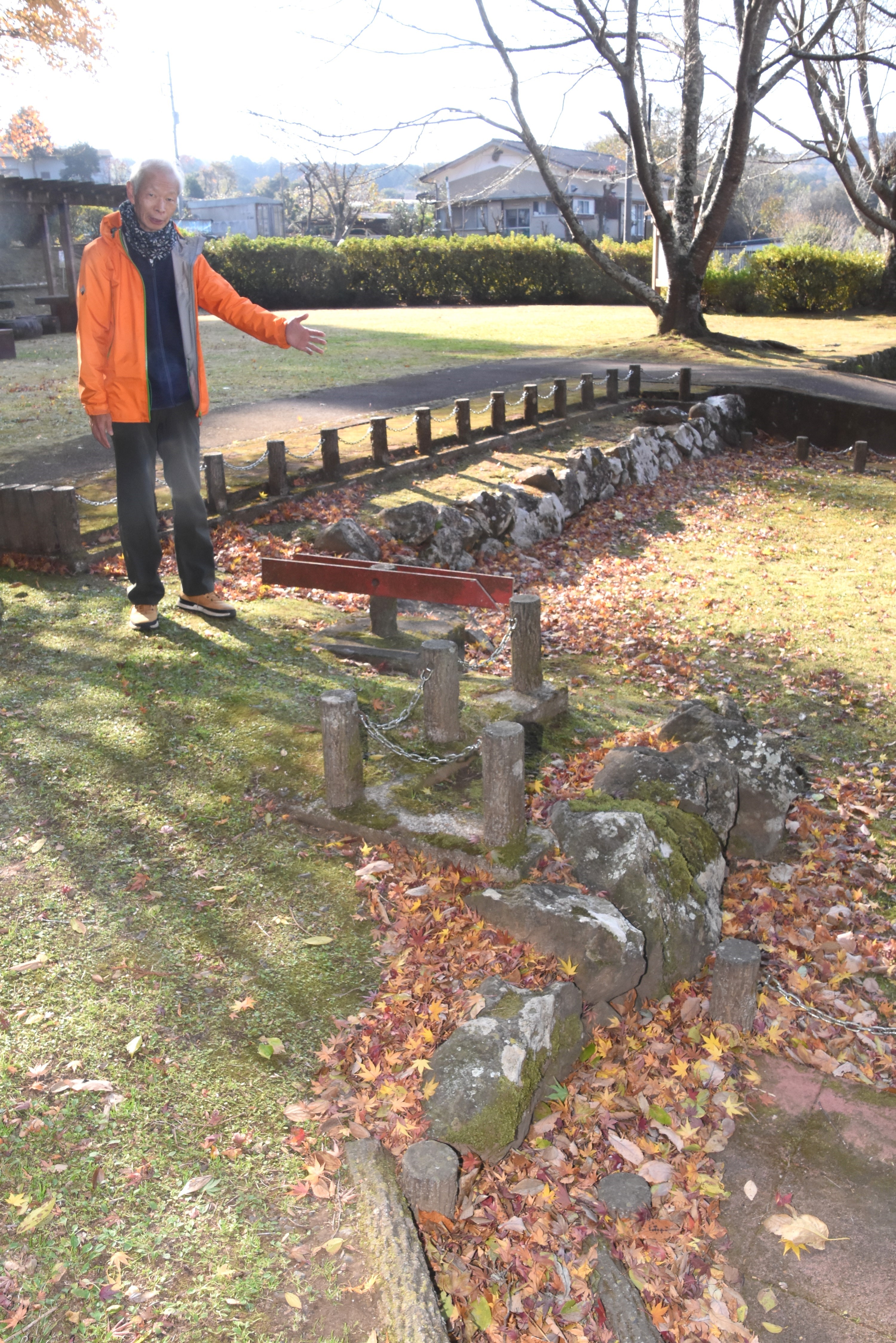 北伊豆地震で２・６メートルのずれが生じた石垣を紹介する大坂さん＝函南町畑の丹那断層公園