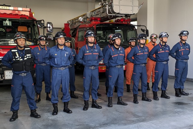 激励に耳を傾ける第２陣として派遣された７人（前列）＝熱海市消防署車庫