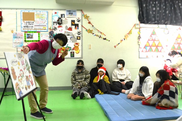 クリスマス会でパネルシアターを披露する職員（左）＝伊東市和田の玖須美児童館（１２月２３日）