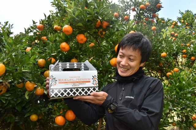 機能性表示食品と記載された新しいパッケージを手にする土屋さん＝松崎町那賀の三余農園