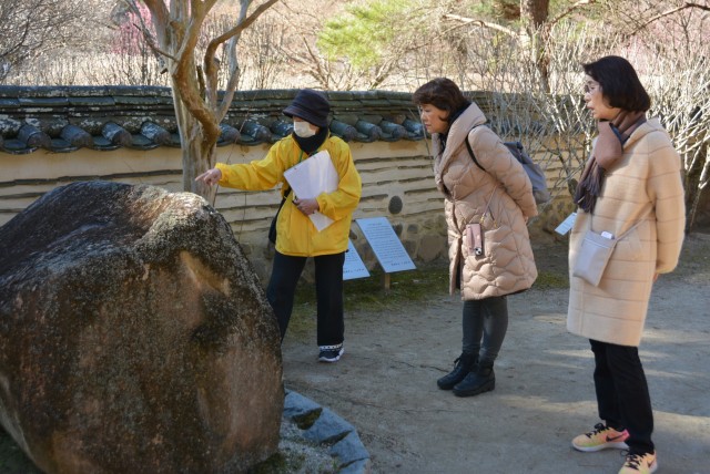 韓国庭園について説明する会員（左）＝熱海市の熱海梅園