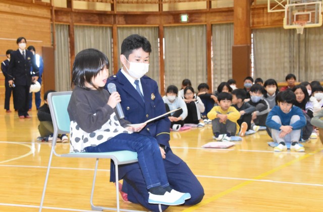 １１０番通報を疑似体験する児童（左手前）＝伊豆市の熊坂小体育館